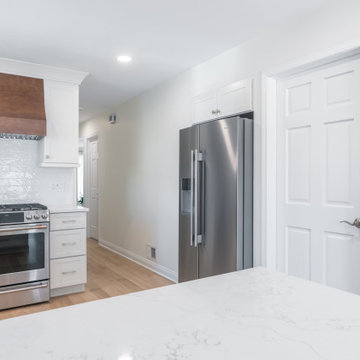 Copper-Toned Range Hood Over White Tile Backsplash