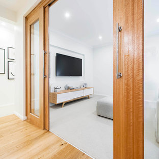 Large danish enclosed carpeted home theater photo in Canberra - Queanbeyan with white walls and a wall-mounted tv