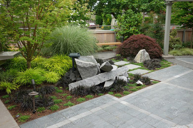 This is an example of a mid-sized industrial backyard shaded formal garden for summer in Portland with concrete pavers.