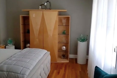Eclectic master light wood floor bedroom photo in New York with gray walls