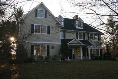 This is an example of a mid-sized traditional two-storey beige exterior in New York with wood siding and a gable roof.