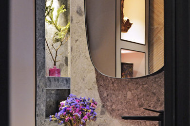 Cette image montre une petite salle de bain principale avec une baignoire encastrée, WC suspendus, un carrelage gris, des dalles de pierre, un mur rose, un sol en terrazzo, un lavabo posé, un sol gris, un plan de toilette gris et meuble simple vasque.