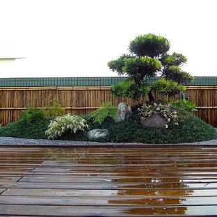 Bild på ett mellanstort orientaliskt flerfärgat hus, med platt tak och tak i mixade material