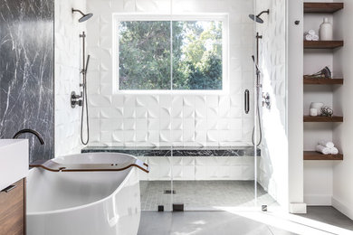 This is an example of a contemporary master bathroom in Sacramento with a freestanding tub, a double shower, black tile, white tile, white walls, grey floor and a hinged shower door.