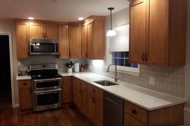 Example of a transitional kitchen design in Philadelphia with an undermount sink, shaker cabinets, quartzite countertops, gray backsplash and stainless steel appliances