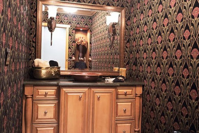Photo of a mid-sized traditional powder room in Denver with raised-panel cabinets, light wood cabinets, a one-piece toilet, multi-coloured walls, a vessel sink, granite benchtops and beige floor.