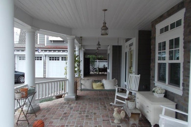 Mid-sized farmhouse brick front porch idea in San Diego with a roof extension