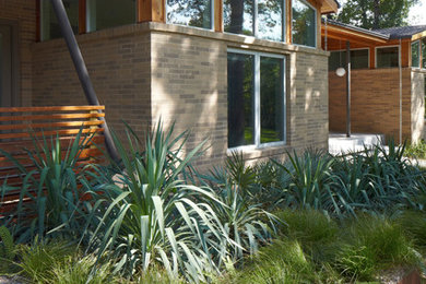 Inspiration for a mid-sized mid-century modern front yard gravel landscaping in Austin.