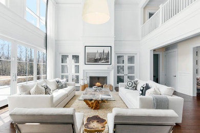 Inspiration for a large beach style formal open concept living room in New York with white walls, a standard fireplace, dark hardwood floors, a tile fireplace surround, no tv and brown floor.