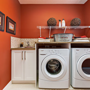 Ejemplo de cuarto de lavado lineal, clásico renovado, de tamaño medio, con fregadero encastrado, armarios estilo shaker, puertas de armario blancas, paredes rojas y lavadora y secadora juntas