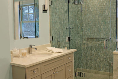 Mid-sized traditional master bathroom in Boston with recessed-panel cabinets, grey cabinets, an undermount tub, an alcove shower, a wall-mount toilet, green tile, glass tile, blue walls, marble floors, an undermount sink, engineered quartz benchtops, green floor, a hinged shower door and white benchtops.
