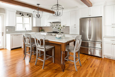Inspiration for a mid-sized traditional l-shaped kitchen in Minneapolis with a farmhouse sink, shaker cabinets, white cabinets, quartzite benchtops, grey splashback, ceramic splashback, stainless steel appliances, with island, brown floor, white benchtop and medium hardwood floors.