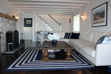 Inspiration for a large coastal enclosed dark wood floor living room remodel in Boston with white walls, a standard fireplace, a stone fireplace and a tv stand