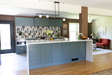 オマハにある高級な中くらいなミッドセンチュリースタイルのおしゃれなキッチン (アンダーカウンターシンク、フラットパネル扉のキャビネット、緑のキャビネット、クオーツストーンカウンター、磁器タイルのキッチンパネル、シルバーの調理設備、セメントタイルの床、グレーの床、白いキッチンカウンター) の写真