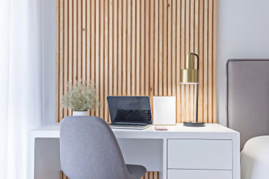 Imagen de despacho de tamaño medio con paredes multicolor, suelo de madera clara, escritorio independiente y suelo beige