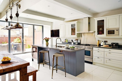 Inspiration for a large contemporary single-wall porcelain tile and white floor eat-in kitchen remodel in DC Metro with an undermount sink, raised-panel cabinets, white cabinets, granite countertops, stainless steel appliances, an island and black countertops