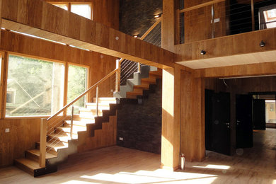 Свежая идея для дизайна: большая угловая лестница в современном стиле с деревянными ступенями и деревянными перилами - отличное фото интерьера