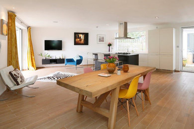 Design ideas for a large contemporary kitchen/dining combo in London with white walls and ceramic floors.