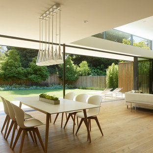 Offenes Modernes Esszimmer mit beiger Wandfarbe, hellem Holzboden, Gaskamin, Kaminsims aus Metall und beigem Boden in San Francisco