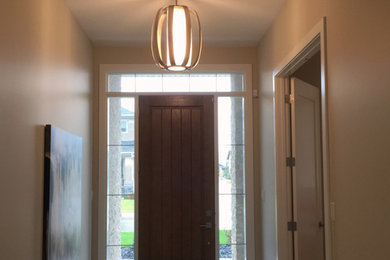 Inspiration for a mid-sized contemporary porcelain tile entryway remodel in Other with beige walls and a dark wood front door