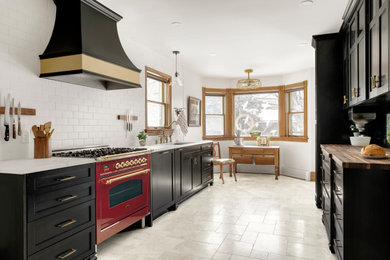 Example of a large ornate galley marble floor and beige floor eat-in kitchen design in Minneapolis with an undermount sink, shaker cabinets, black cabinets, marble countertops, white backsplash, subway tile backsplash, colored appliances, no island and white countertops