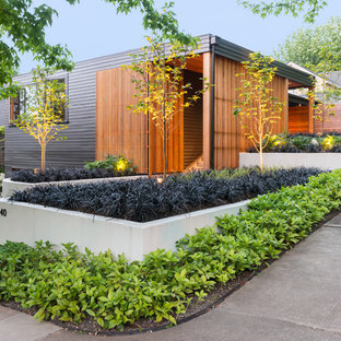 Mid-sized contemporary two-storey exterior in Portland with wood siding and a flat roof.