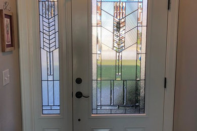 Modelo de puerta principal rústica con paredes beige, suelo de madera oscura, puerta simple, puerta blanca y suelo marrón