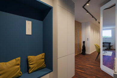 На фото: фойе среднего размера в стиле модернизм с синими стенами, темным паркетным полом, синей входной дверью и коричневым полом с