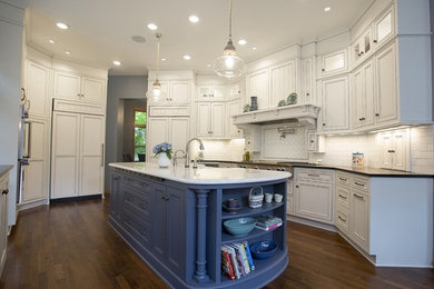 This is an example of a large traditional eat-in kitchen in Minneapolis with a farmhouse sink, recessed-panel cabinets, white cabinets, quartzite benchtops, white splashback, subway tile splashback, panelled appliances, dark hardwood floors and with island.