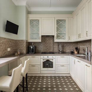 Удачное сочетание для дизайна помещения: отдельная, п-образная кухня среднего размера в стиле современная классика с одинарной раковиной, фасадами с выступающей филенкой, бежевыми фасадами, коричневым фартуком, фартуком из керамической плитки, коричневым полом, коричневой столешницей, столешницей из акрилового камня, белой техникой и полом из керамогранита без острова - самое интересное для вас