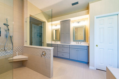 Beach style bathroom in Tampa with beige cabinets and a double vanity.