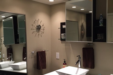 Inspiration for a large contemporary 3/4 beige tile and porcelain tile porcelain tile bathroom remodel in Los Angeles with a vessel sink, flat-panel cabinets, brown cabinets, solid surface countertops and beige walls