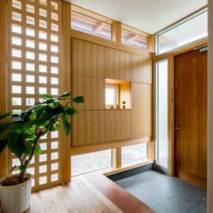他の地域の片開きドアアジアンスタイルのおしゃれな玄関 (木目調のドア、グレーの床) の写真