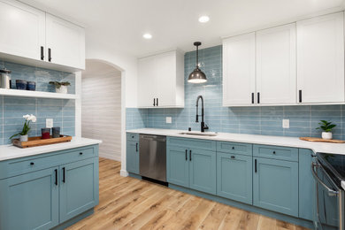 Kitchen - mid-sized transitional light wood floor and brown floor kitchen idea in Seattle with an undermount sink, shaker cabinets, blue cabinets, quartz countertops, blue backsplash, ceramic backsplash, stainless steel appliances and white countertops