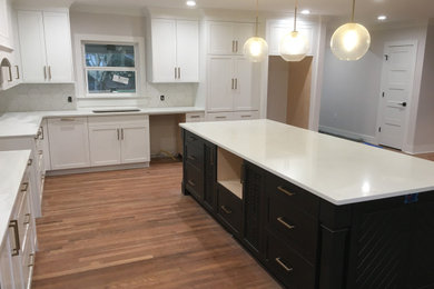 Photo of a traditional kitchen/diner in Jackson with shaker cabinets, white cabinets, engineered stone countertops and an island.