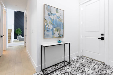 Example of a large 1950s laminate floor and brown floor mudroom design in Calgary with white walls