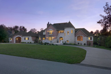 Large traditional red two-story brick gable roof idea in St Louis
