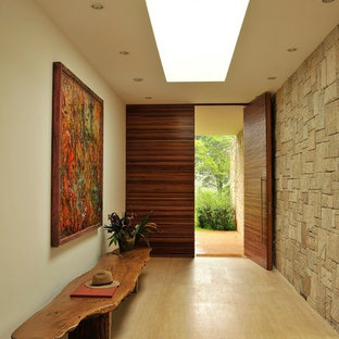 На фото: большие узкие прихожие в современном стиле с бежевыми стенами, поворотной входной дверью и входной дверью из дерева среднего тона