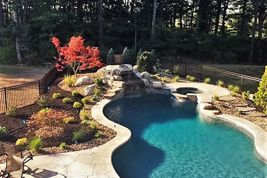Large transitional backyard stone and custom-shaped pool photo in Boston
