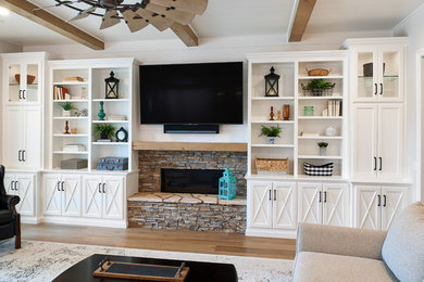 Inspiration for a mid-sized country family room in Orange County with a wood fireplace surround and a wall-mounted tv.