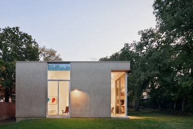Example of a mid-sized minimalist green one-story stucco exterior home design in Austin