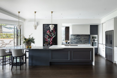 Inspiration for a transitional l-shaped dark wood floor and brown floor eat-in kitchen remodel in Auckland with an undermount sink, blue cabinets, quartzite countertops, blue backsplash, stone slab backsplash, stainless steel appliances, an island and blue countertops