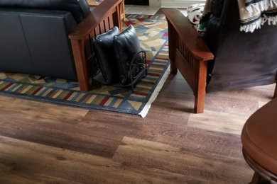 Photo of a mid-sized transitional open concept living room in Portland with white walls, vinyl floors and brown floor.