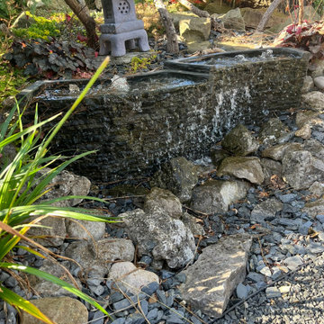 Pondless waterfall design with slate walling and natural stone landscaping detai