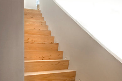 Exempel på en modern rak trappa i trä, med sättsteg i trä