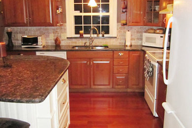 Kitchen - medium tone wood floor kitchen idea in Boston with a double-bowl sink, beaded inset cabinets, medium tone wood cabinets, beige backsplash, white appliances and an island