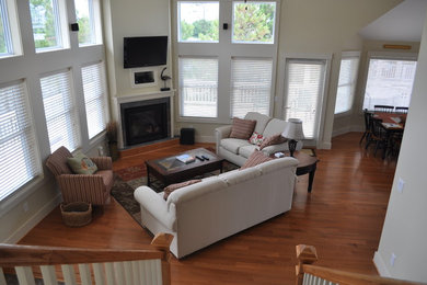 Example of a mid-sized classic open concept medium tone wood floor living room design in Other with a stone fireplace, white walls, a standard fireplace and a wall-mounted tv