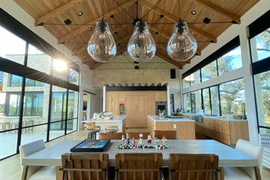 Foto de comedor de cocina abovedado moderno grande con paredes blancas y suelo de madera clara