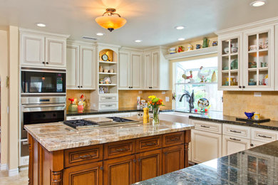 Photo of an u-shaped kitchen in San Diego with a farmhouse sink, recessed-panel cabinets, white cabinets, yellow splashback and with island.