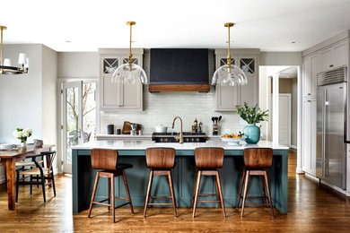 Inspiration for a mid-sized transitional galley dark wood floor and brown floor eat-in kitchen remodel in DC Metro with shaker cabinets, white cabinets, quartz countertops, white backsplash, subway tile backsplash, black appliances, an island and white countertops
